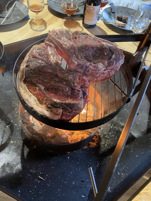 Steaks saisis sur les flammes du grill à La Cour d'Hortense, Sailly-Flibeaucourt, avec verres de vin en arrière-plan