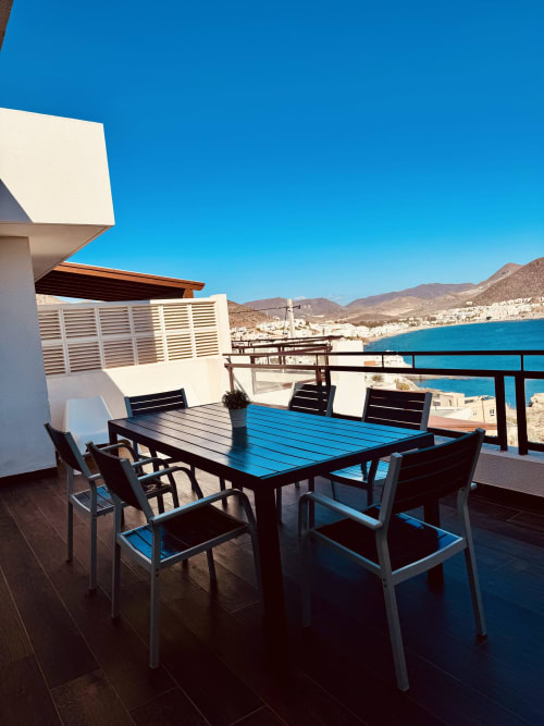 Terraza con vistas al mar Mediterráneo turquesa en El Faro de los Genoveses, mesa de comedor frente a la costa de Almería