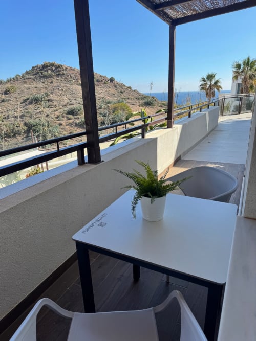 Terraza con vistas al mar en El Faro De Los Genoveses, con maceta, mesa de comedor y vista a las colinas del Mediterráneo
