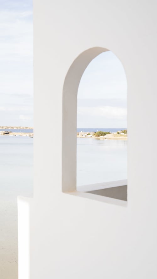 Puerta arqueada blanca que enmarca la vista del mar desde la habitación del hotel Formentera Especial en La Savina, España