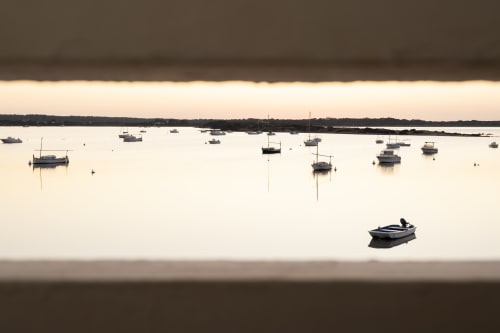 Vista serena del puerto desde villa en Formentera con veleros fondeados y aguas tranquilas en La Savina