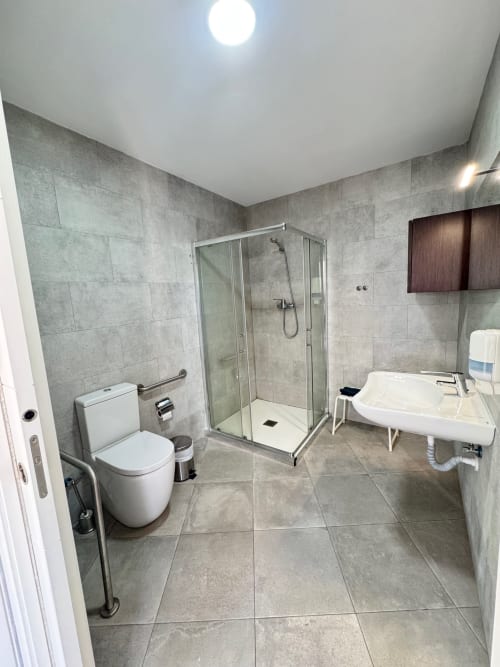 Baño moderno con ducha a ras de suelo, inodoro y lavabo en el apartamento El Faro De Los Genoveses, San José, Almería