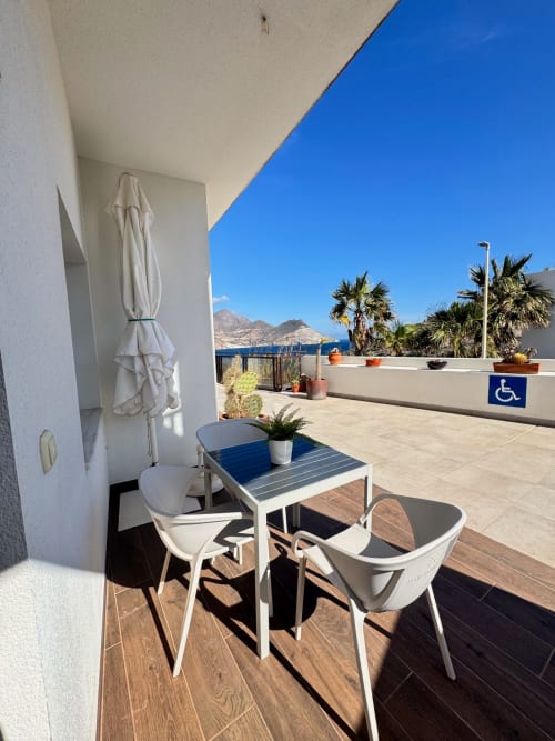 Terraza frente al mar en El Faro De Los Genoveses con mobiliario blanco, vistas al mar y palmeras en San José, Almería