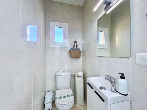 Baño moderno en la casita La Vela de Estartit Rental con inodoro, lavabo, espejo y amenidades