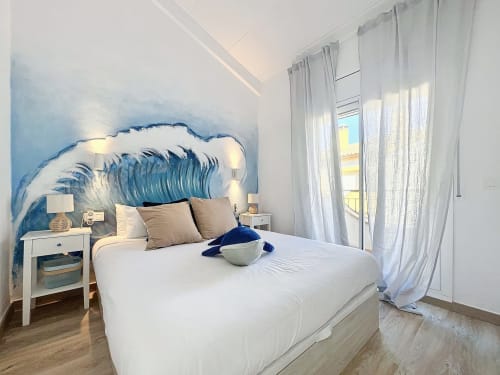 Dormitorio moderno con cabecero de olas, ropa de cama blanca y vistas al mar en la casa rural La Vela de Estartit