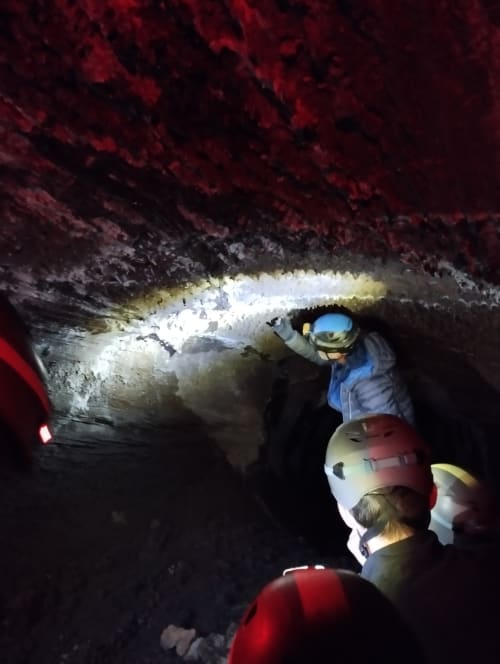 Esploratori di grotte con lampade frontali in visita a una caverna sotterranea presso l'Hotel Milomax a Milo, Sicilia
