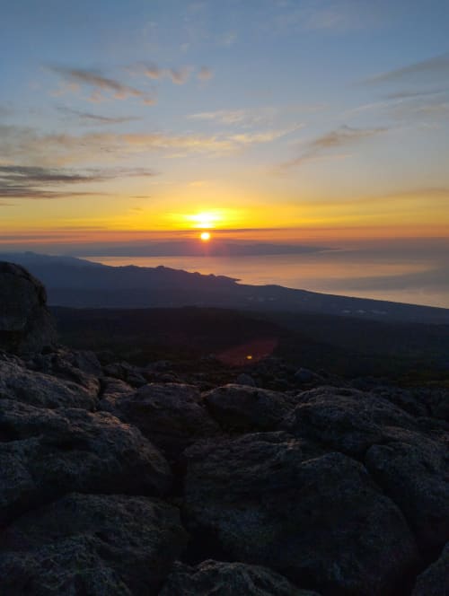 Vista del tramonto da una roccia panoramica con vista su Milo, Sicilia, con montagne e costa