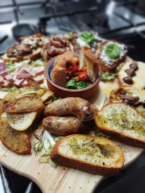 Tagliere di salumi gourmet all'Hotel Milomax con pane alle erbe, salsicce grigliate, affettati e verdure fresche