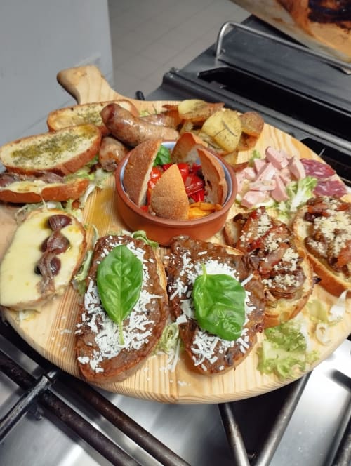 Tagliere gourmet all'Hotel Milomax con carni curate, pani artigianali, verdure grigliate e basilico fresco
