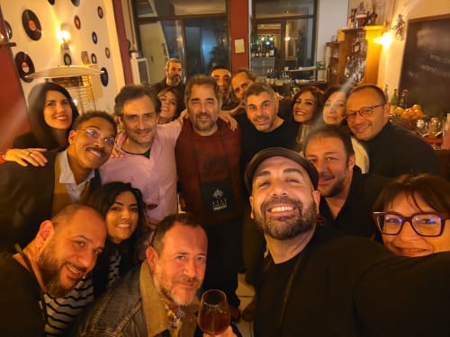 Gruppo di ospiti sorridenti riuniti insieme all'Hotel Milomax a Milo, Italia durante un incontro sociale