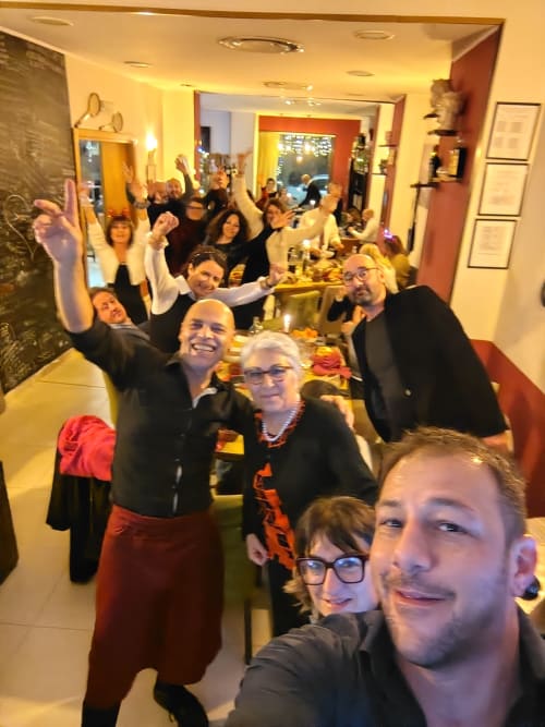 Gli ospiti dell'Hotel Milomax brindano e sorridono in una sala da pranzo illuminata con calore