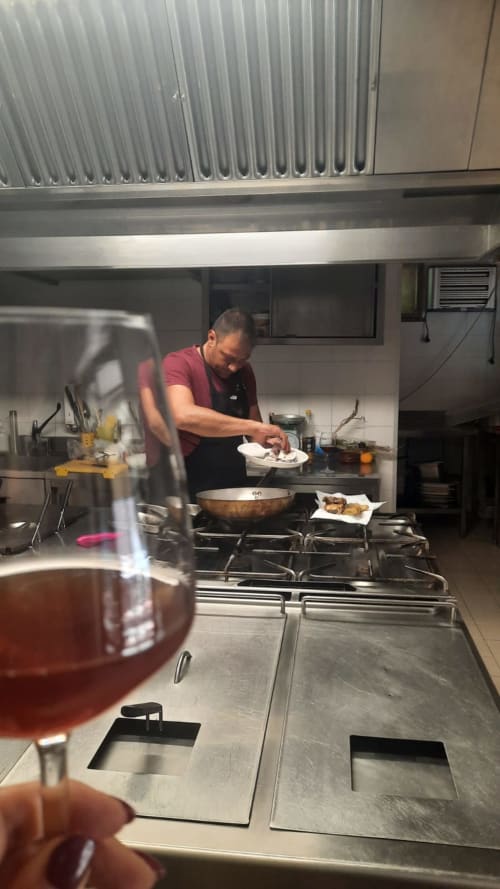 Chef che prepara piatti in cucina dell'Hotel Milomax, Milo CT con wok e piatti in presentazione