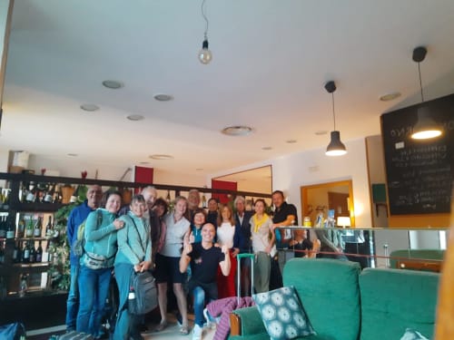Ampio gruppo riunito nella hall dell'Hotel Milomax a Milo, CT, con illuminazione moderna e sedute verdi