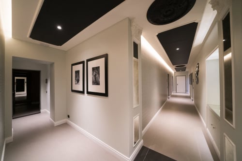 Corridoio moderno del Seven Suites Sanremo con opere d'arte incorniate in bianco e nero, illuminazione soffusa e design contemporaneo