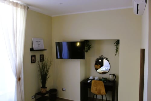 Camera moderna del Blackwoody Contemporary Hospitality Naples con TV a schermo piatto, scrivania e vista sulla città