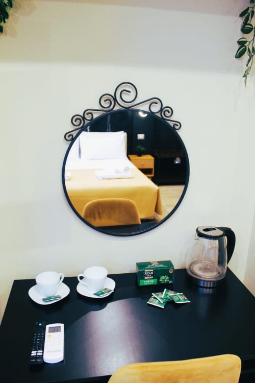 Scrivania con servizio tè, bollitore elettrico e specchio decorativo nella camera d'hotel di Blackwoody Contemporary a Napoli