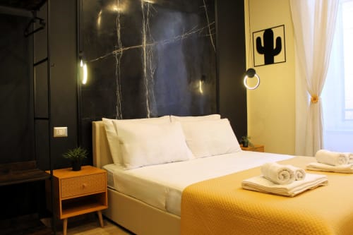 Camera moderna di Blackwoody Contemporary Hospitality a Napoli con parete accent gialla, testata in marmo e asciugamani arrotolati