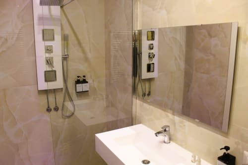 Bagno moderno con lavandino bianco, ampio specchio, cabina doccia in vetro e piastrelle di marmo a Blackwoody Contemporary