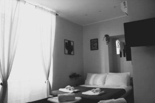 Camera da letto moderna a Blackwoody Contemporary Hospitality a Napoli con letto matrimoniale, tende bianche e vista sulla città