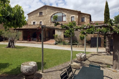 Can Gat Vell, masía de piedra rústica con pérgola en Empordà, Girona, con terraza y jardines impecables