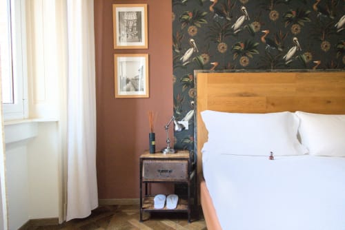 Elegante Camera Doppia Superiore a Porta Tosa Milano con letto in legno, pareti in terracotta, carta da parati scura decorata e vista sulla città
