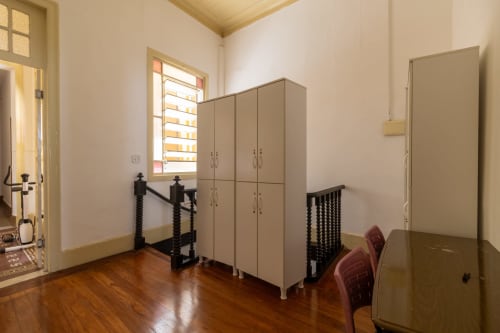 Quarto de dormitório misto no Rio Vibes Hostel com beliches, piso de madeira, guarda-roupa e luz natural da janela