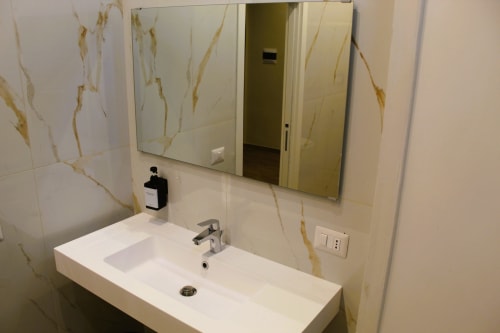 Bagno moderno con piastrelle effetto marmo bianco, lavabo rettangolare, specchio e rubinetto cromato a Blackwoody Contemporary