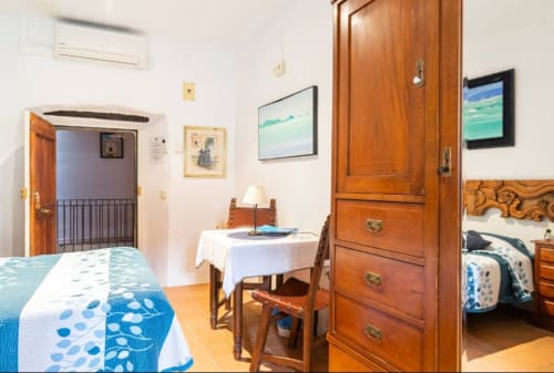 Dormitorio rústico en el alojamiento Can Gat Vell de Girona con muebles de madera, ropa de cama azul y decoración tradicional