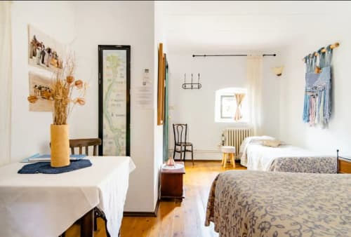 Habitación luminosa con camas gemelas, suelos de madera y decoración rústica en Can Gat Vell B&B en Girona