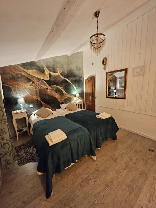 Elegantes Schlafzimmer im Le Manoir Lacustre mit zwei Betten, künstlerischem Kopfteil, Kronleuchter und Gartenblick in Queyrac, Frankreich