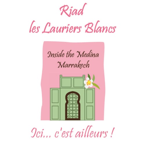Riad Les Lauriers Blancs à la médina de Marrakech avec portes vertes et fleurs blanches sur fond rose