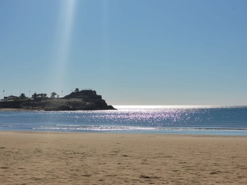 Plage de sable avec mer turquoise et promontoire rocheux à Puerto de Mazarrón, Espagne
