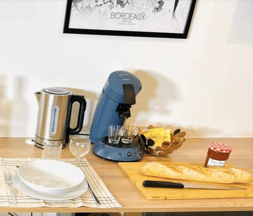 Wellkhome Bordeaux kitchen setup with kettle, coffee machine, bread, and place setting