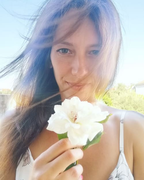 Mujer sosteniendo una flor blanca en Casa das Jardas, hotel rural en Ladoeiro, Portugal