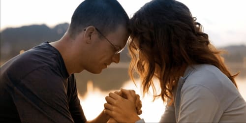 Casal de mãos dadas ao pôr do sol à beira da água perto da acomodação rural Casa das Jardas em Ladoeiro