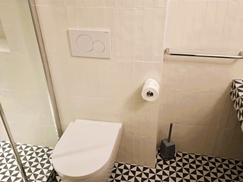 Bagno moderno dell'appartamento Newhouse a Bari con toilette, bidet, rivestimenti in piastrelle e pavimento a motivo geometrico