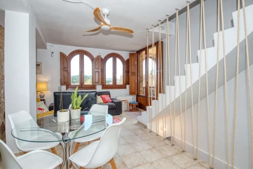 Spacieux séjour-salle à manger ouvert chez Finques Garcia Enrich à Palafrugell avec portes cintrées en bois et ventilateur de plafond