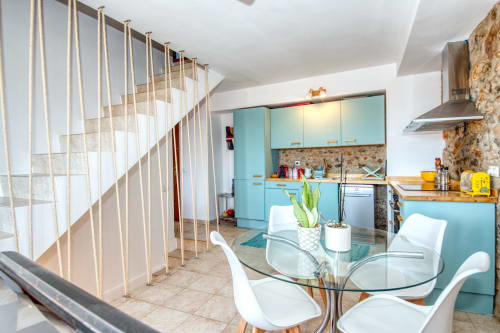 Cuisine et salle à manger modernes aux Finques Garcia Enrich à Palafrugell avec armoires turquoise et table en verre