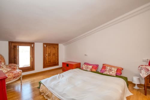 Chambre spacieuse à Finques Garcia Enrich à Palafrugell avec parquet, lit blanc et mobilier coloré