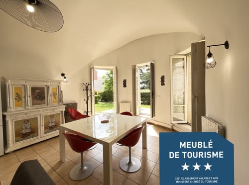 Bright dining area in Blois gîte with white table, burgundy chairs, garden views, and 3-star tourism rating
