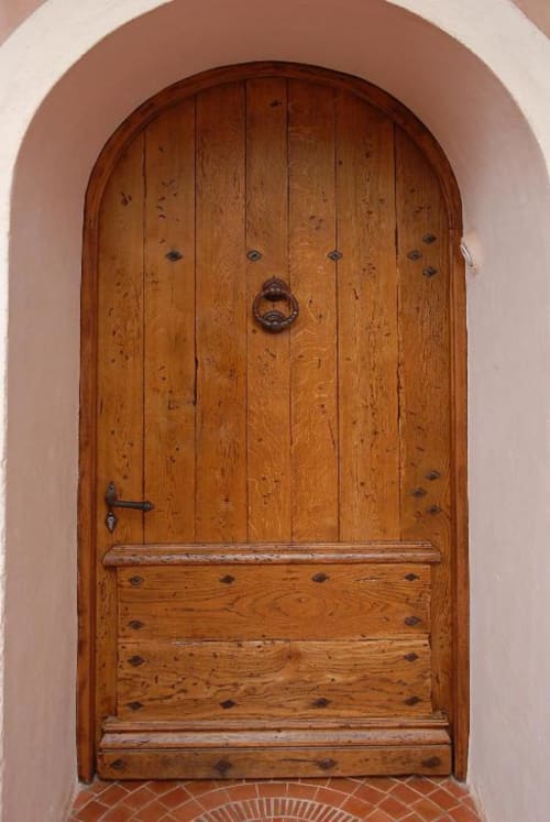 Porte en bois voûtée avec ferrures en fer à la Villa Marina Di Cavu, un gîte bord de mer à Bonifacio, France