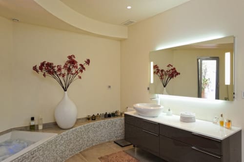 Salle de bain luxueuse avec baignoire îlot, double vasque et fleurs décoratives à la Villa Marina Di Cavu à Bonifacio