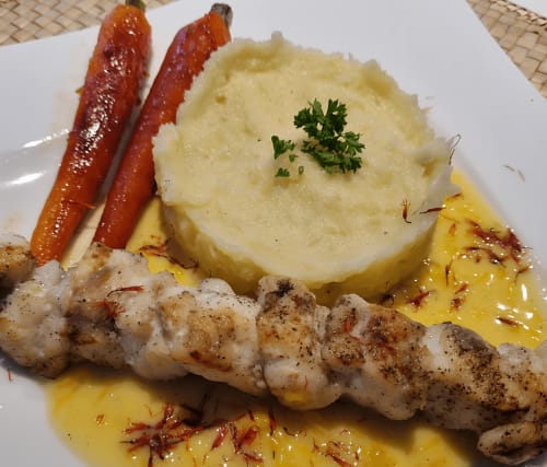 Plat de poisson frais accompagné de légumes de saison rôtis, nappé d'une sauce crémeuse au beurre blanc, servi avec un verre de vin – Ty Coz Breizh, Bretagne, au pays de Lorient.