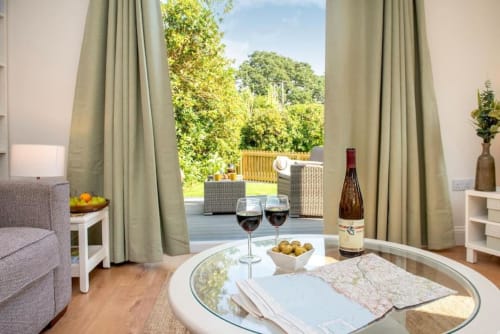 Experience luxury in this holiday home near Tavistock with 1 living room, 1 bedroom, and a walk-in shower. Fully equipped kitchen, terrace with garden views, flat-screen TV, and more amenities. Max occupancy: 4.