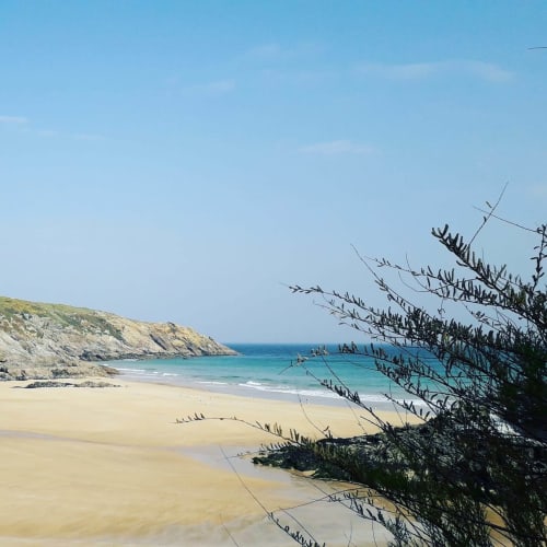 Crique de sable fin aux eaux turquoise et falaises côtières à Locmaria, Belle Île-en-Mer, France