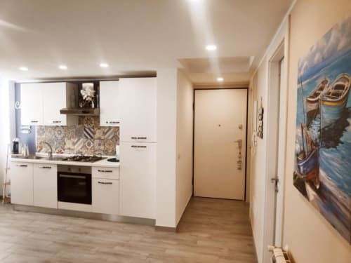 Cucina moderna bianca con rivestimento geometrico nell'appartamento con tre camere del TuffonelBlu, Ventimiglia, Italia