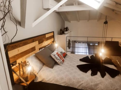 Camera da letto in moderno loft presso TuffonelBru a Ventimiglia con letto in legno, soppalco e vista sul mare