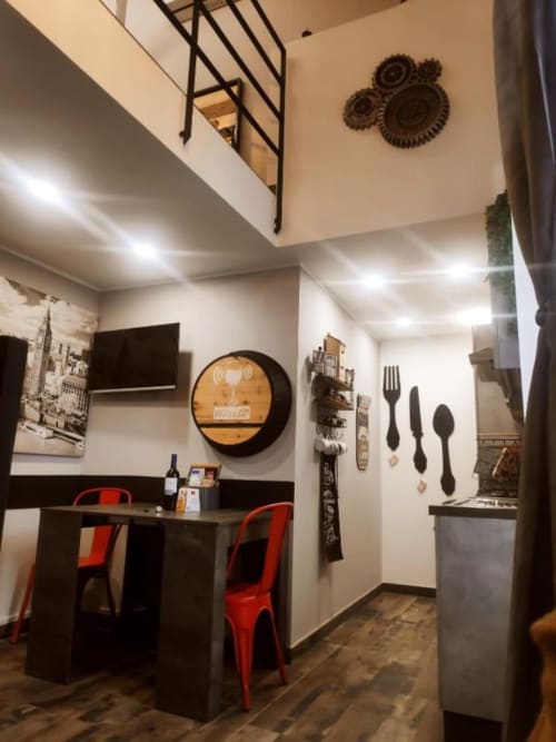 Angolo cottura e zona pranzo moderni dell'appartamento TuffonelBlu a Ventimiglia con sedie rosse e accessori da cucina a parete