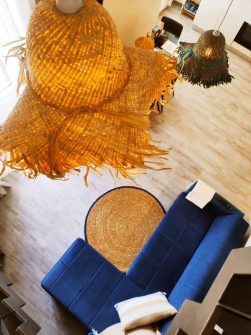 Lampade in vimini e arredi in fibre naturali nell'appartamento trilocale di TuffonelBlu a Ventimiglia con divano blu