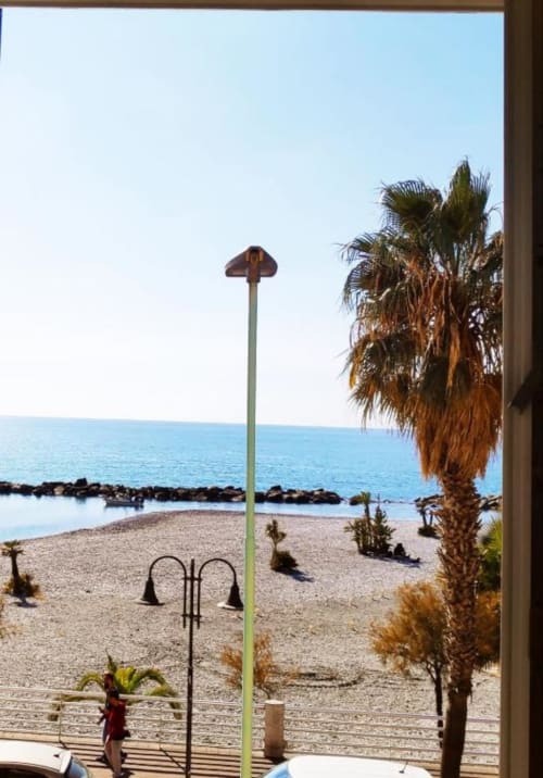 Vista mare dall'appartamento TuffonelBlu a Ventimiglia con palma, spiaggia e lampione
